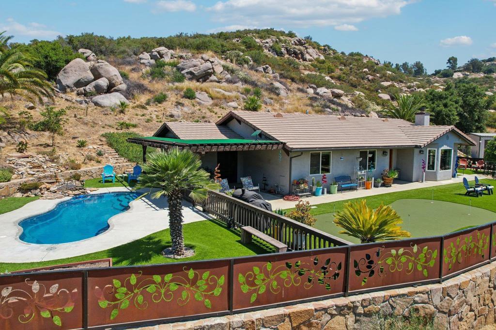 a view of a house with swimming pool and sitting area