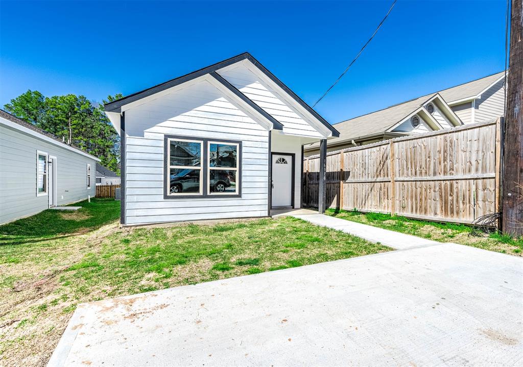 a view of backyard with small cabin and wooden fence