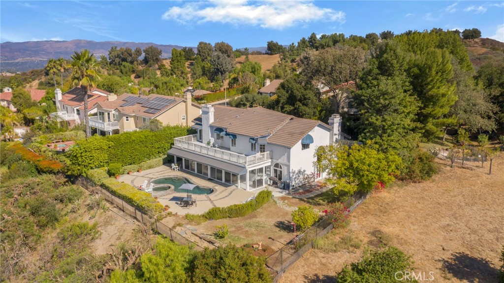 an aerial view of a house with a yard and mountain view in back