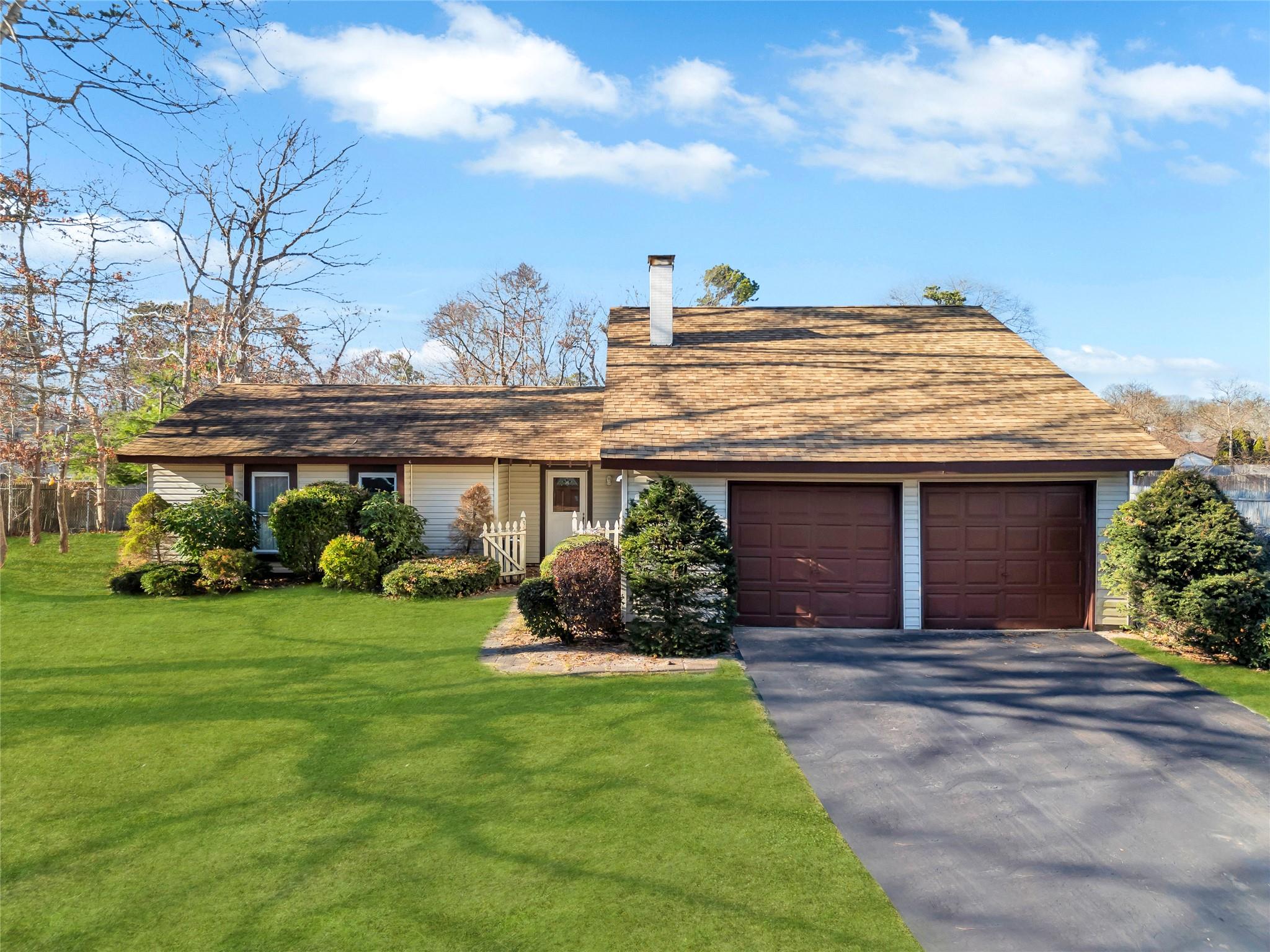 Ranch-style home featuring a garage and a front lawn