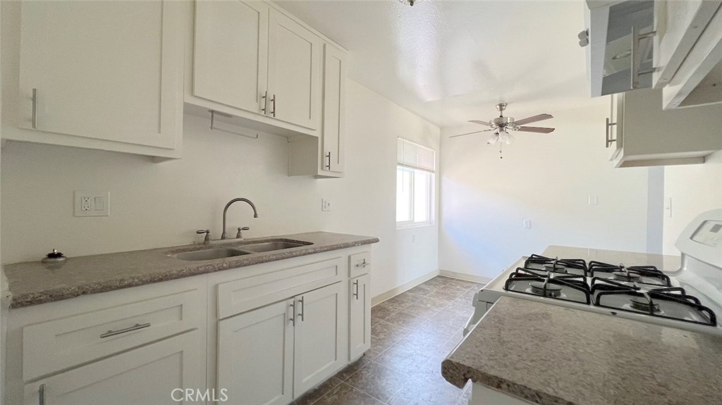 a kitchen with stainless steel appliances granite countertop a sink stove and cabinets