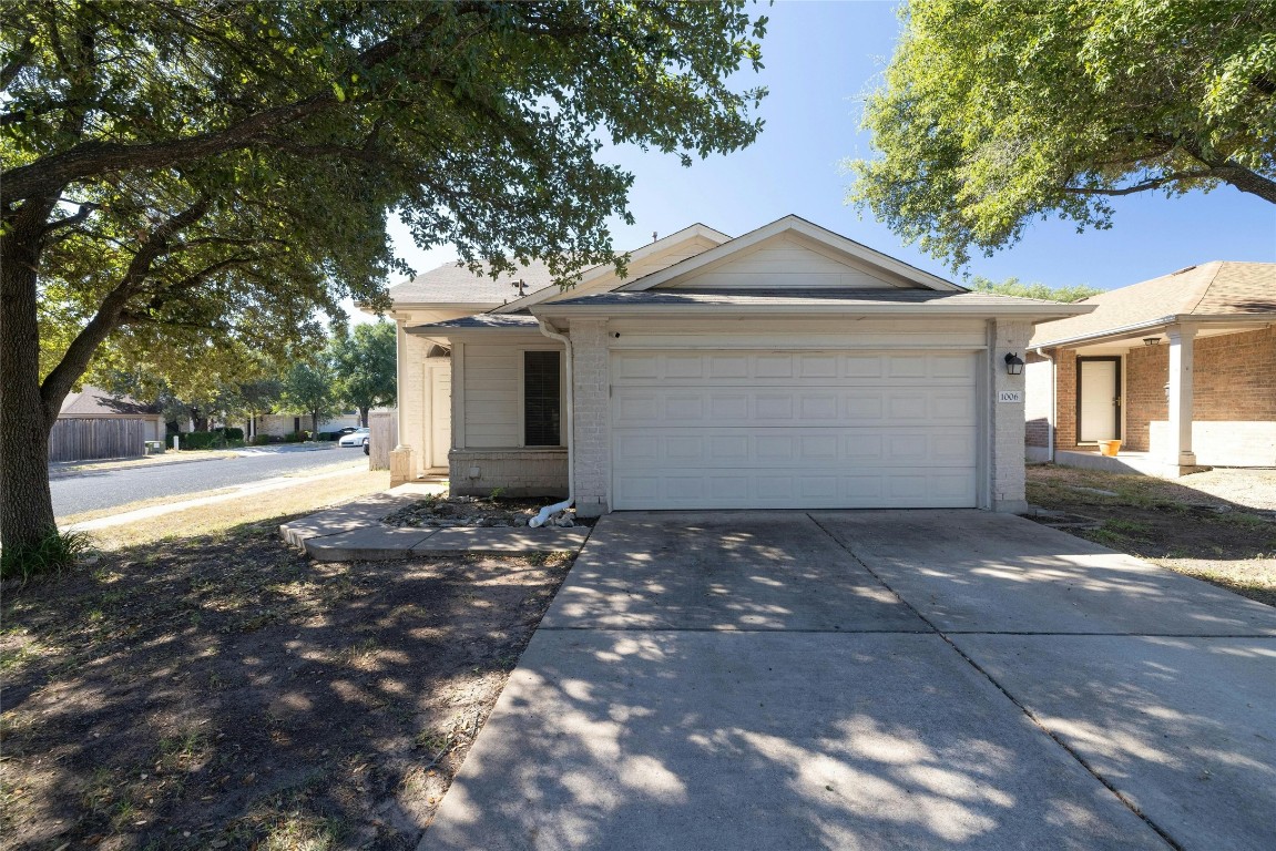 a view of a house with a yard and large tree