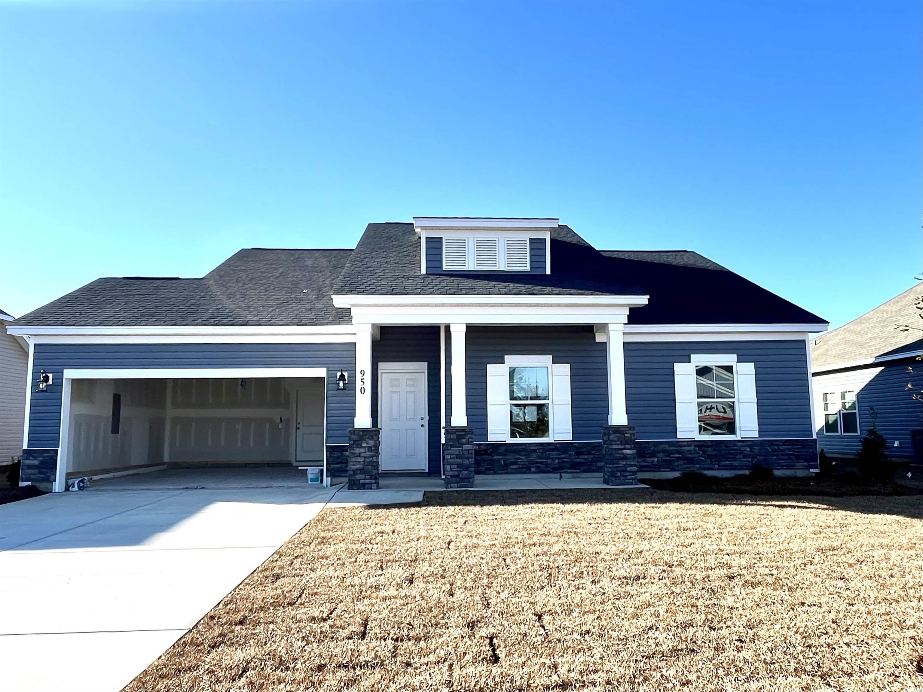 View of front of house with a front yard and a gar