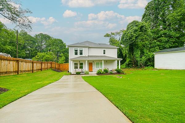 a front view of a house with a yard and trees