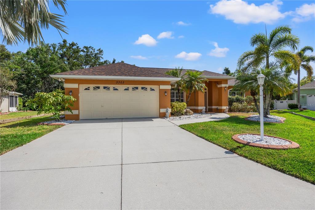 a view of a house with a yard and palm trees