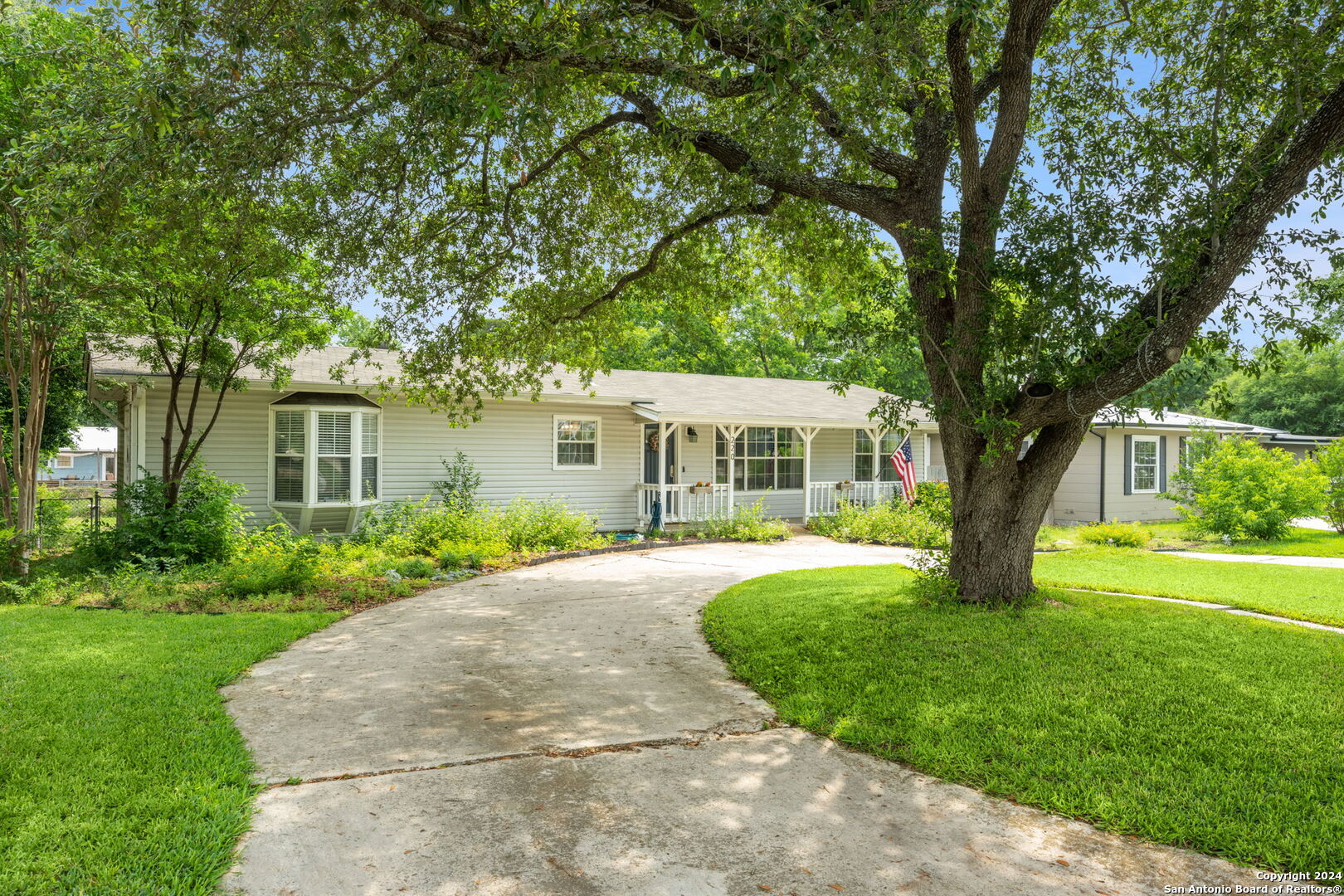 a front view of a house with yard and green space