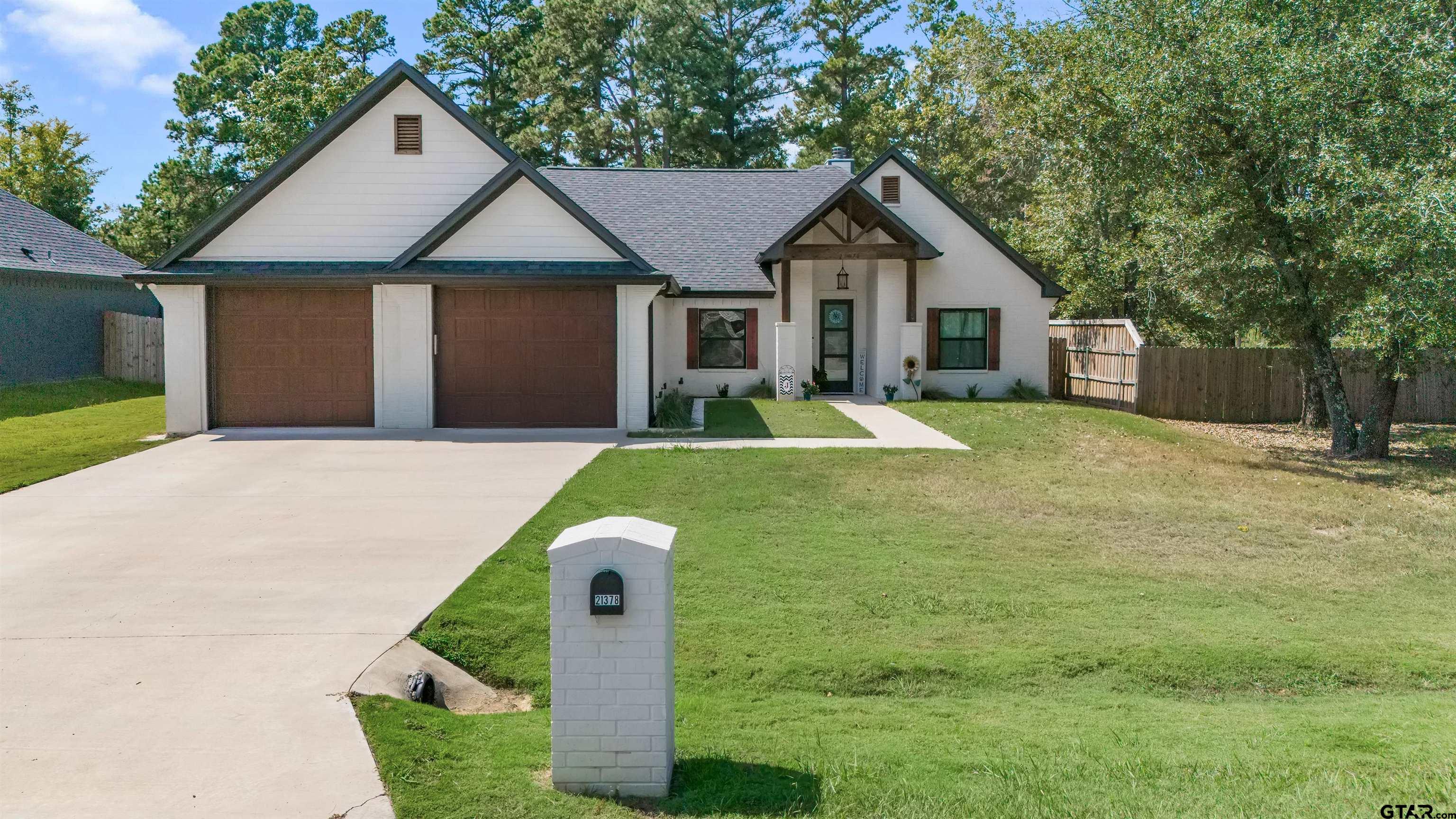 a front view of a house with a yard and trees