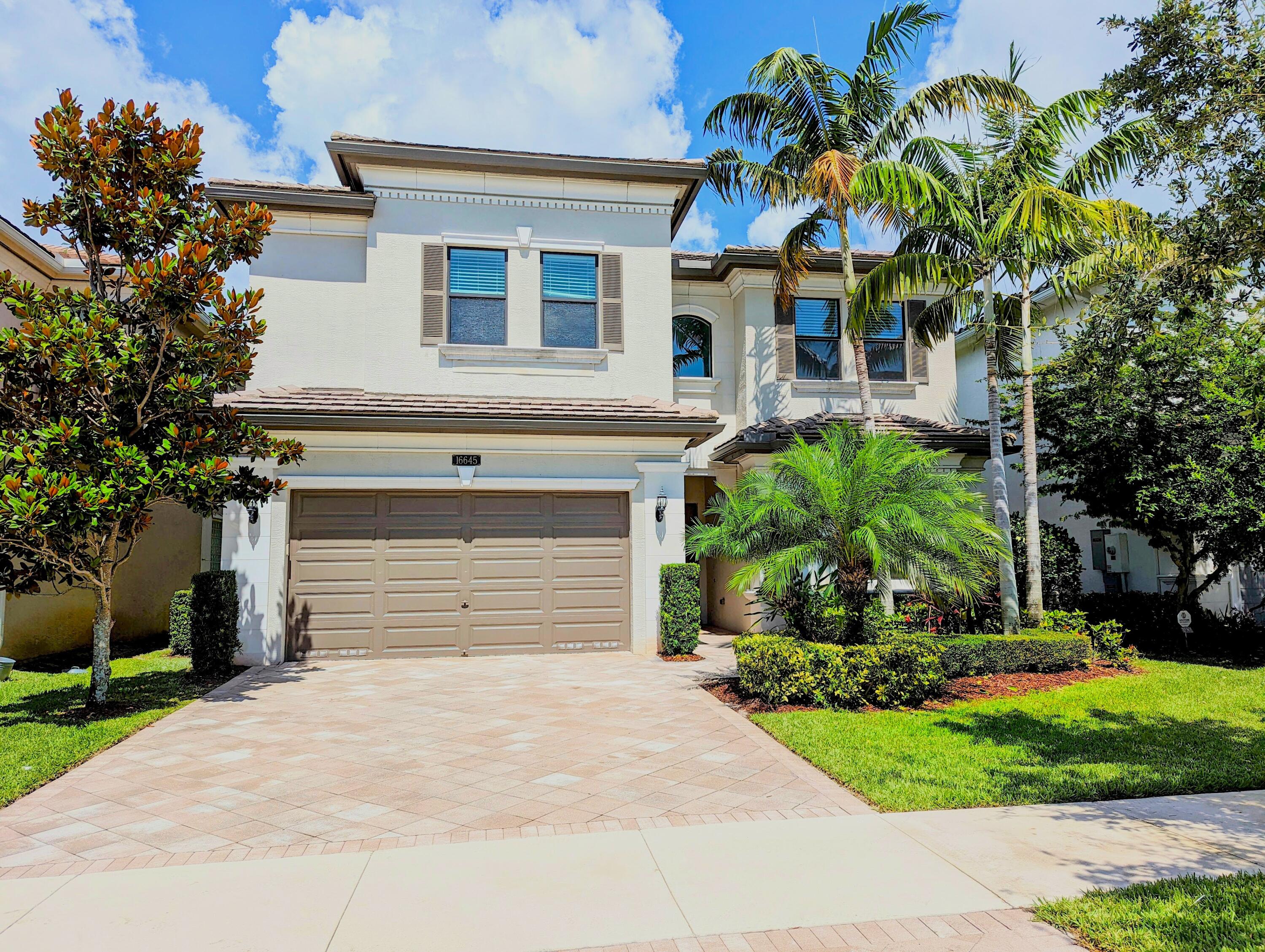 a front view of a house with a yard and a garage