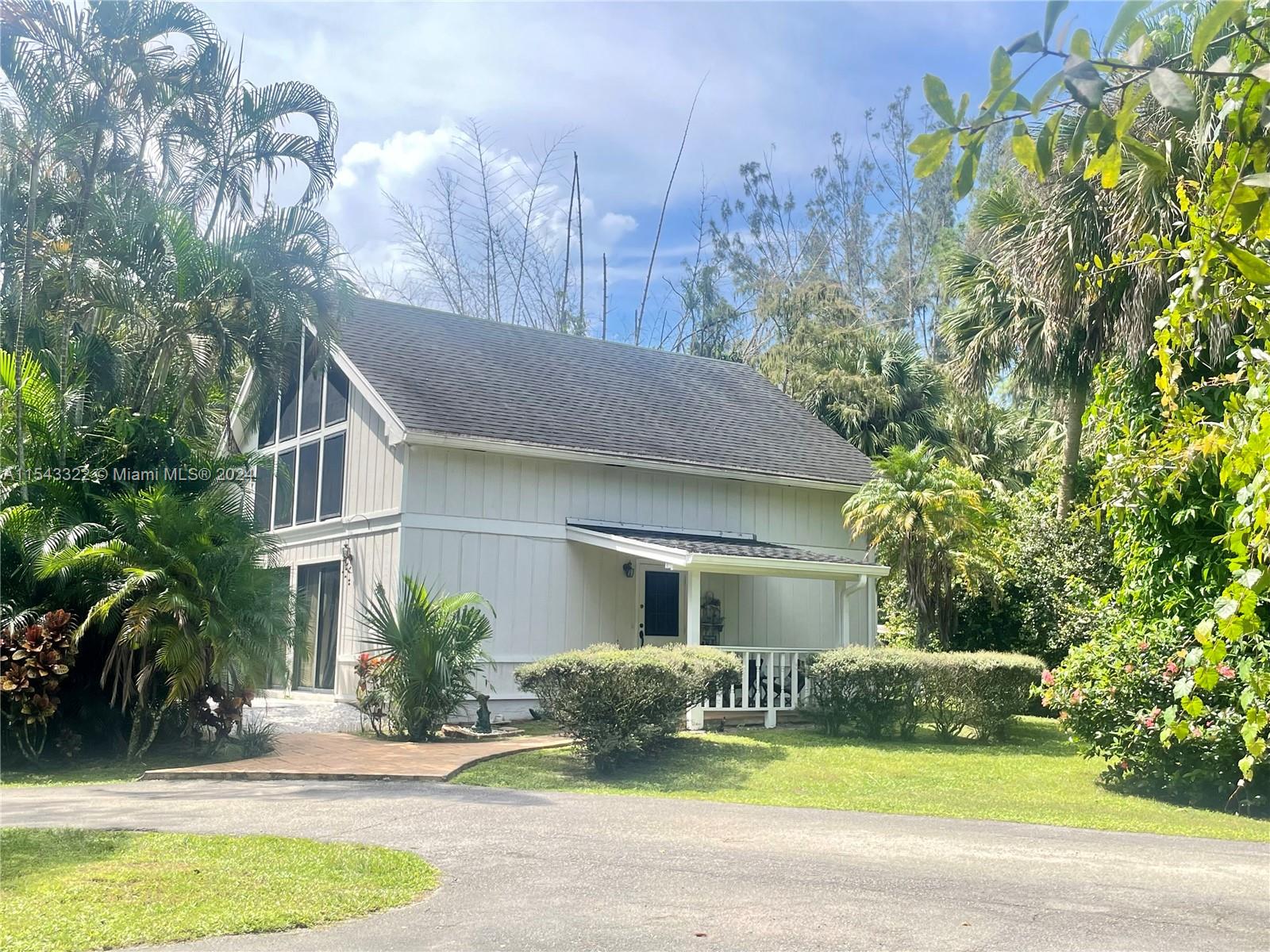 a front view of a house with garden and yard