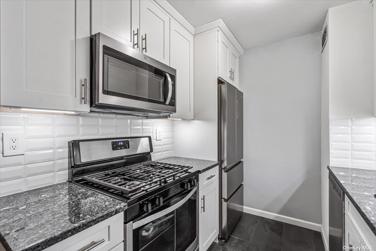 a kitchen with stainless steel appliances granite countertop a stove microwave and sink