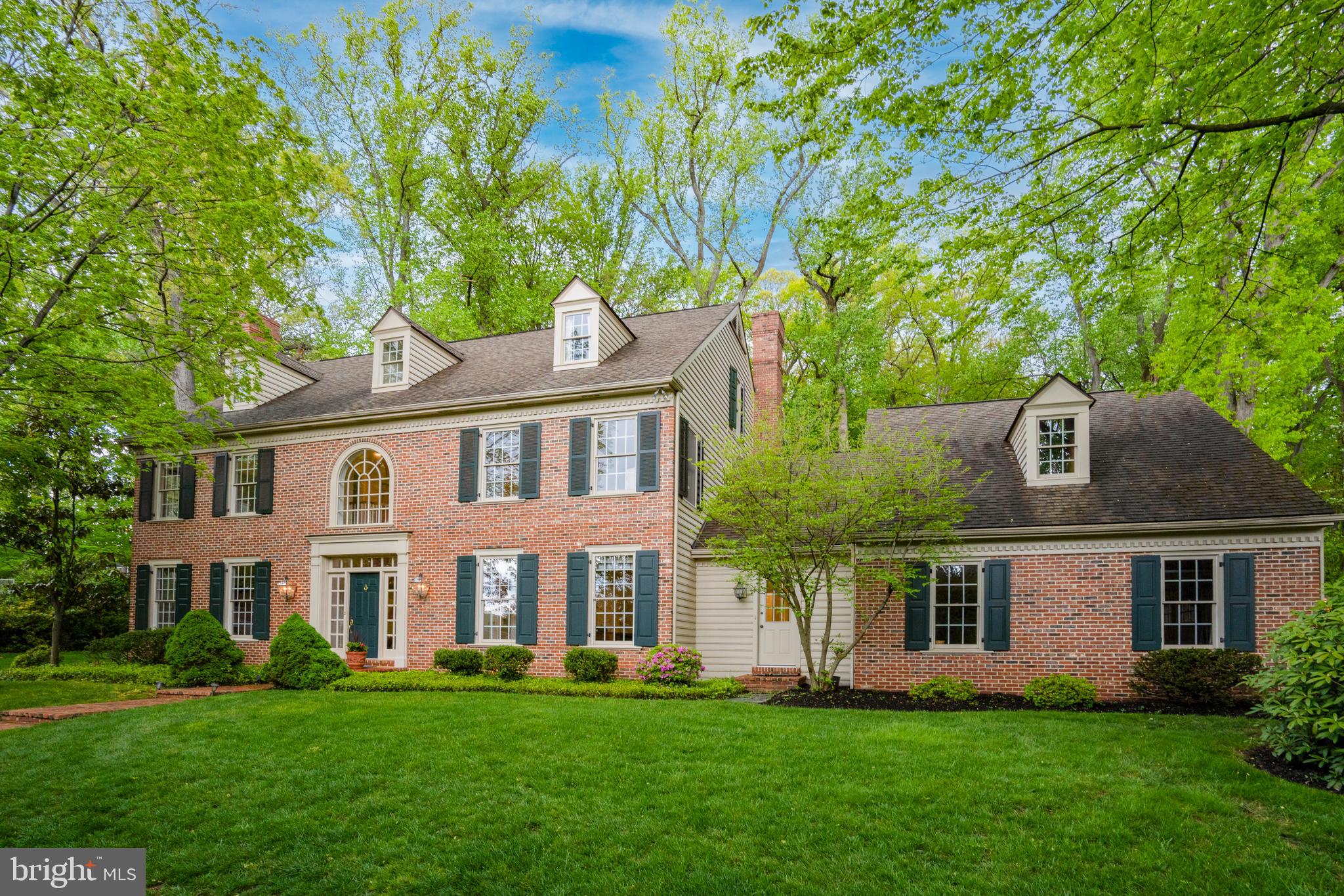 a front view of a house with a yard and trees