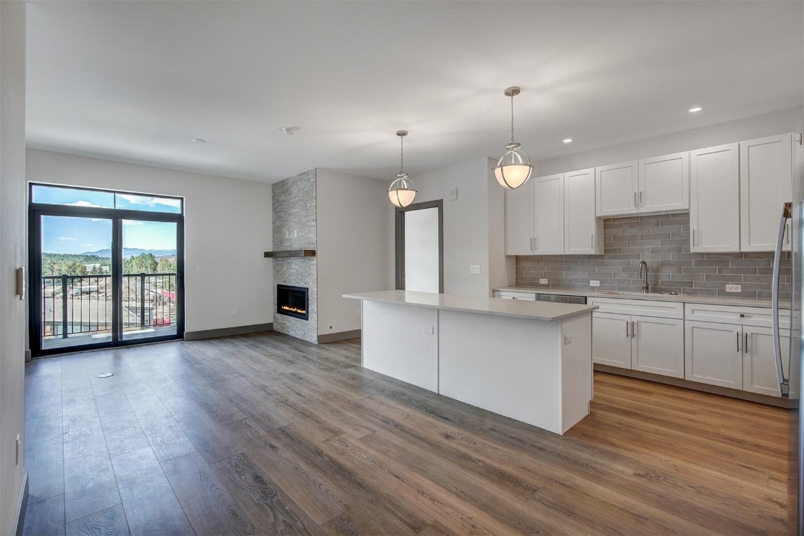 a large kitchen with cabinets wooden floor and stainless steel appliances