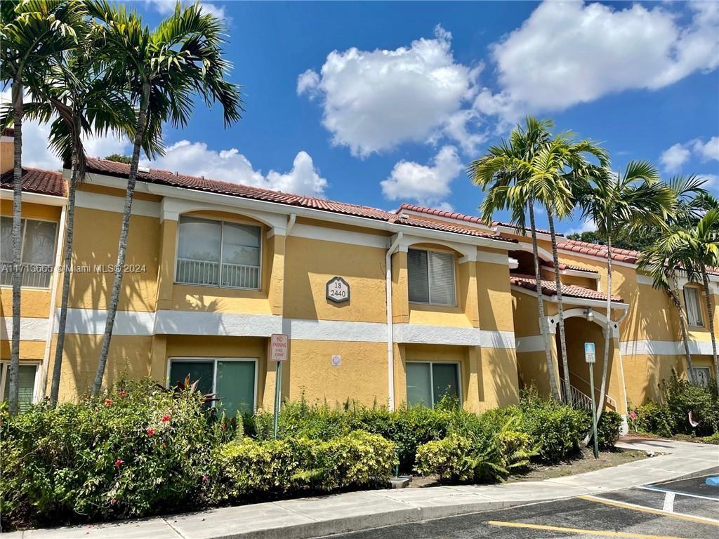 front view of a house with a palm tree