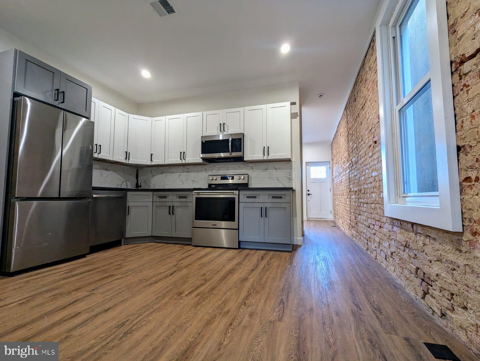 a kitchen with stainless steel appliances granite countertop a refrigerator sink and stove