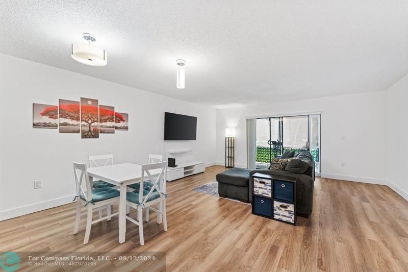 a living room with furniture a flat screen tv and a wooden floor