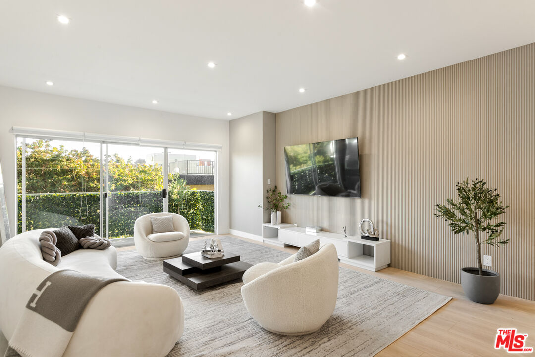 a living room with furniture potted plant and a large window