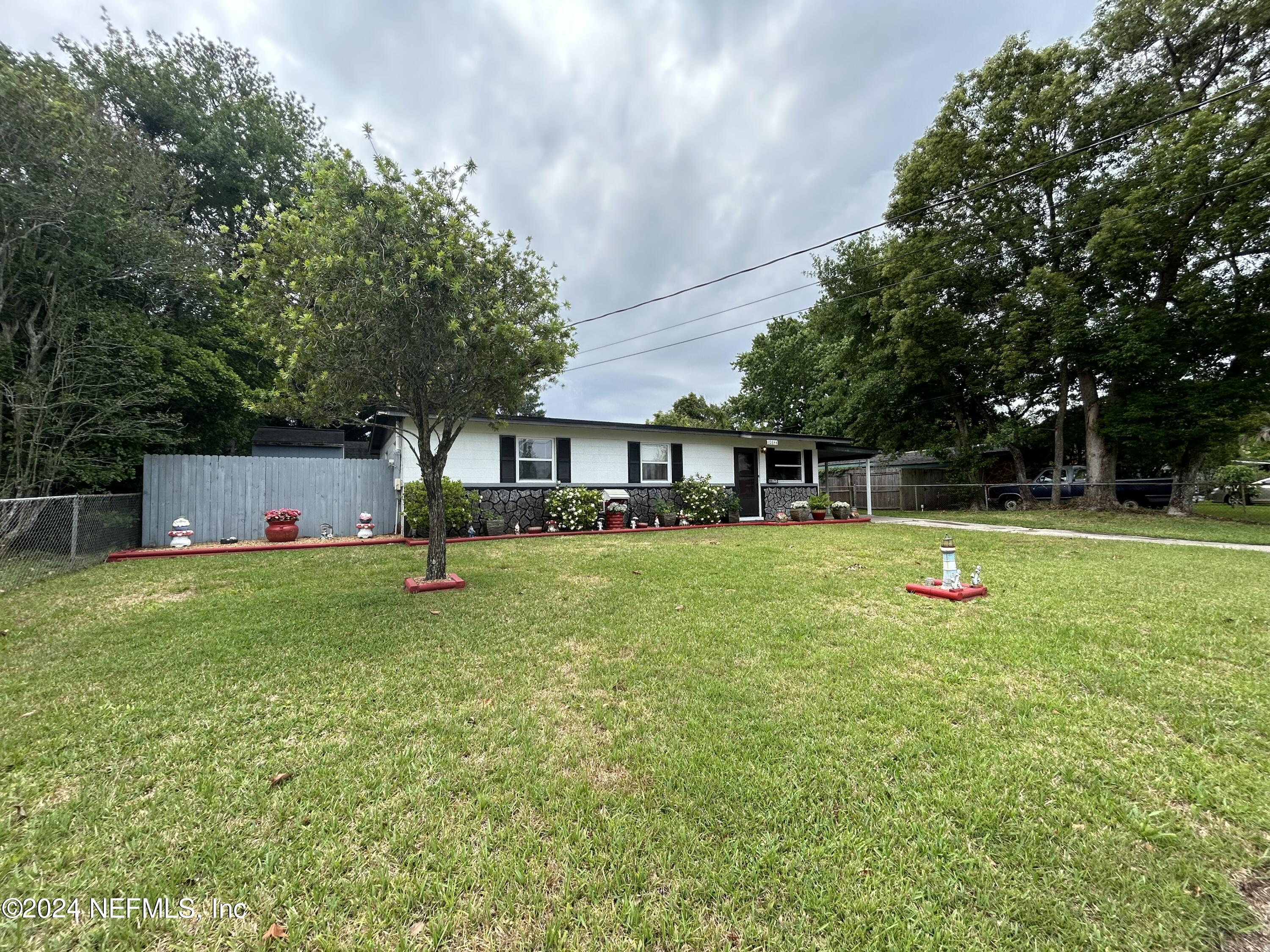 a front view of a house with a yard and tree