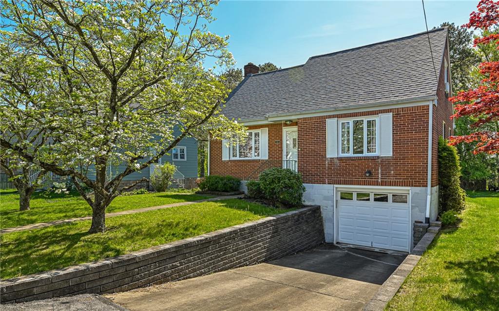 a front view of a house with a yard and a garden