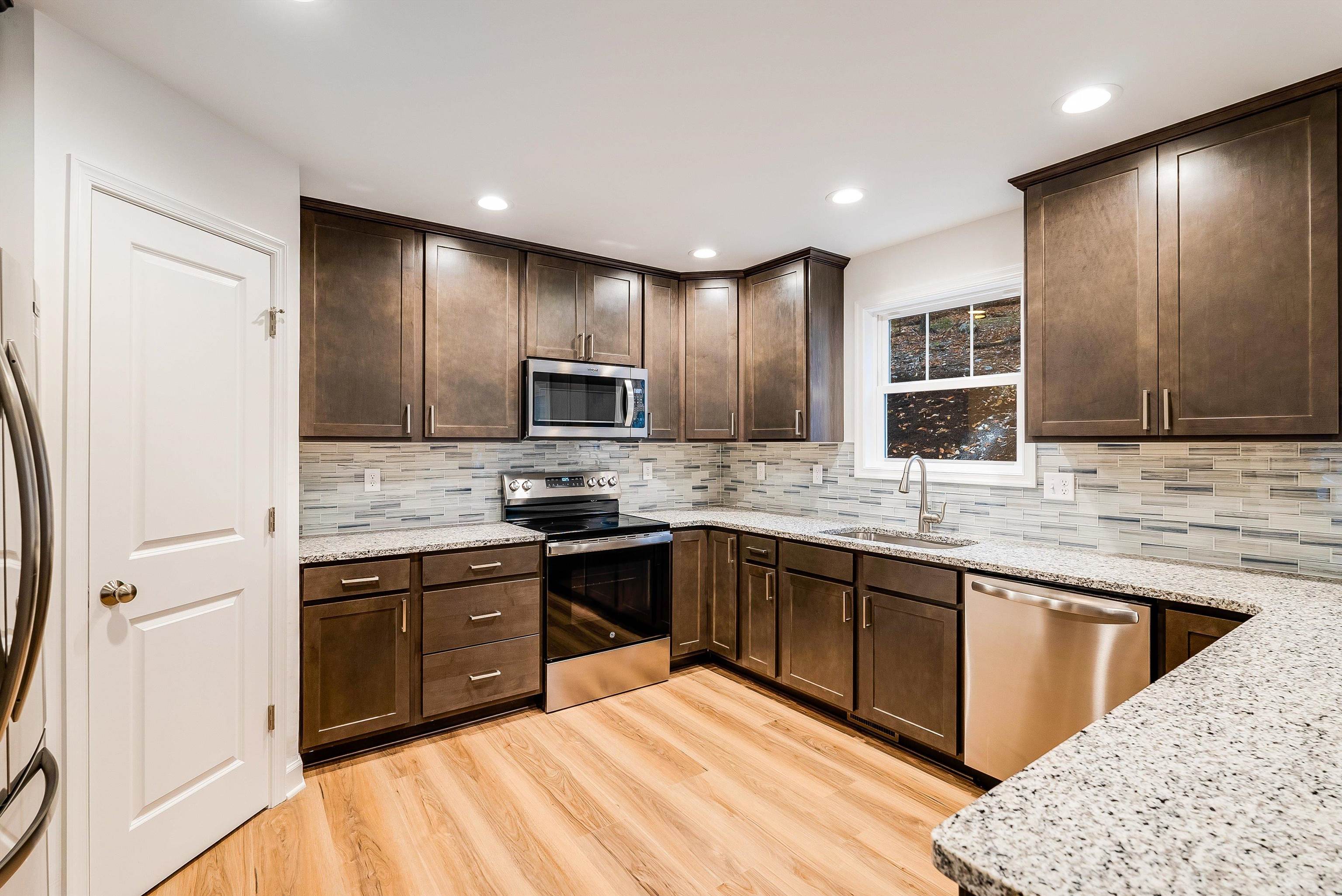 a kitchen with stainless steel appliances granite countertop a sink stove and refrigerator