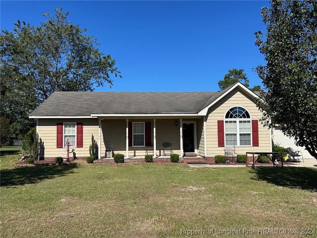 a front view of a house with a yard and trees