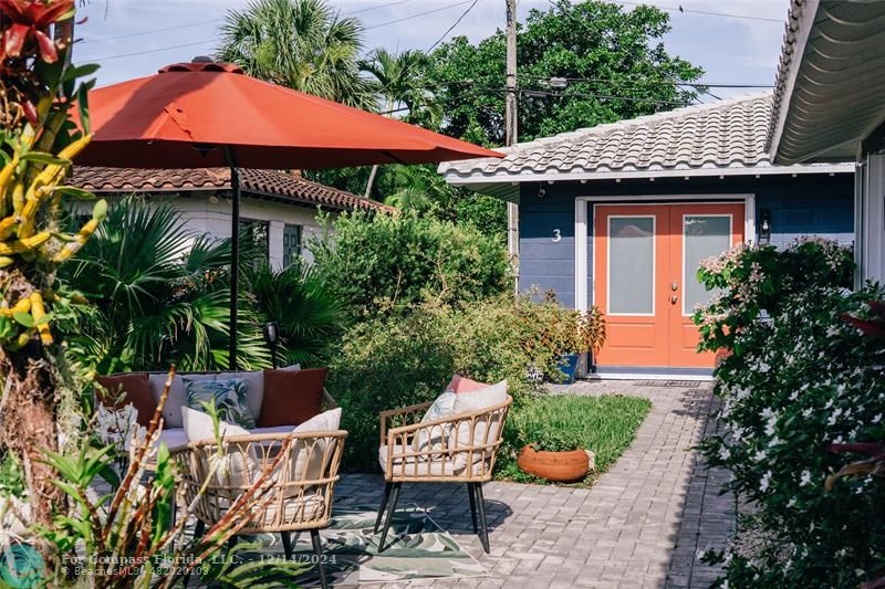 a front view of a house with a yard and potted plants