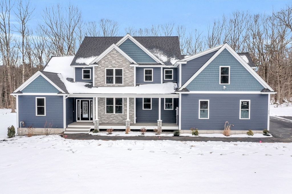 a front view of a house with a yard covered with snow in front of it