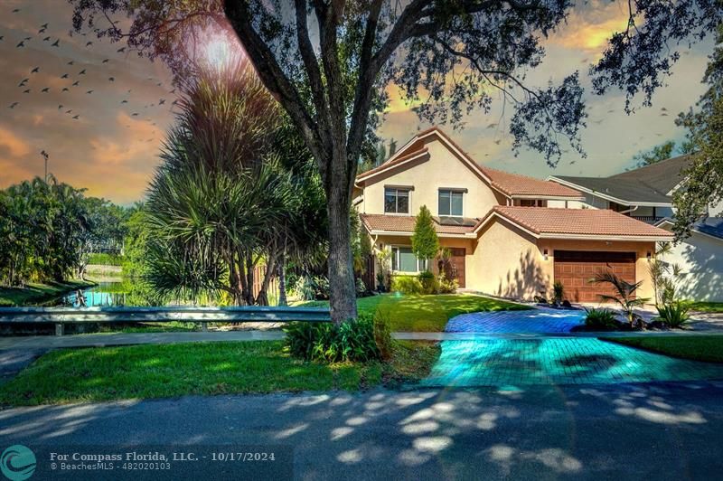 a front view of a house with a yard and trees