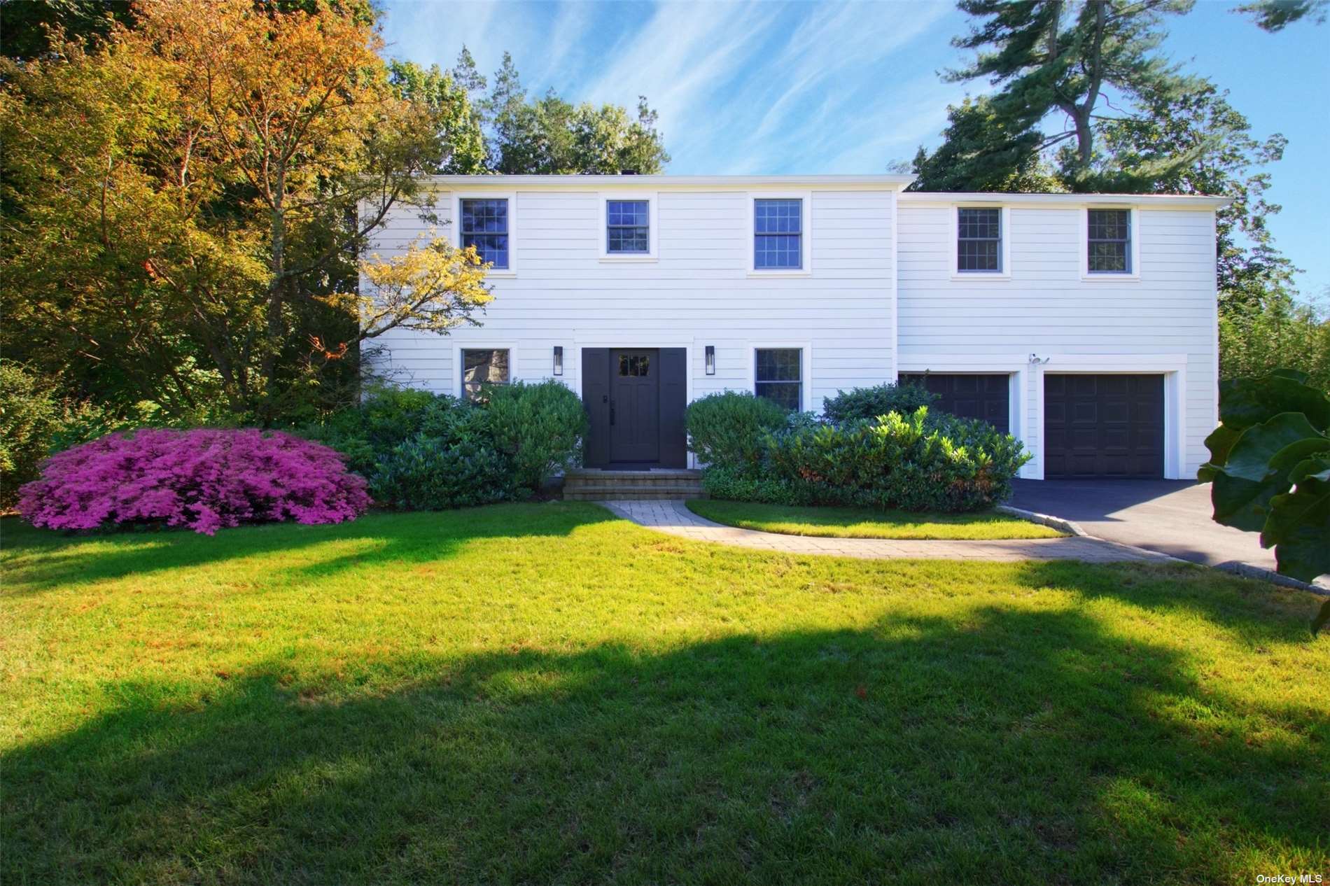 a view of a house with a yard and potted plants