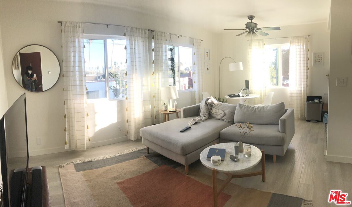 a living room with furniture a large window and a chandelier