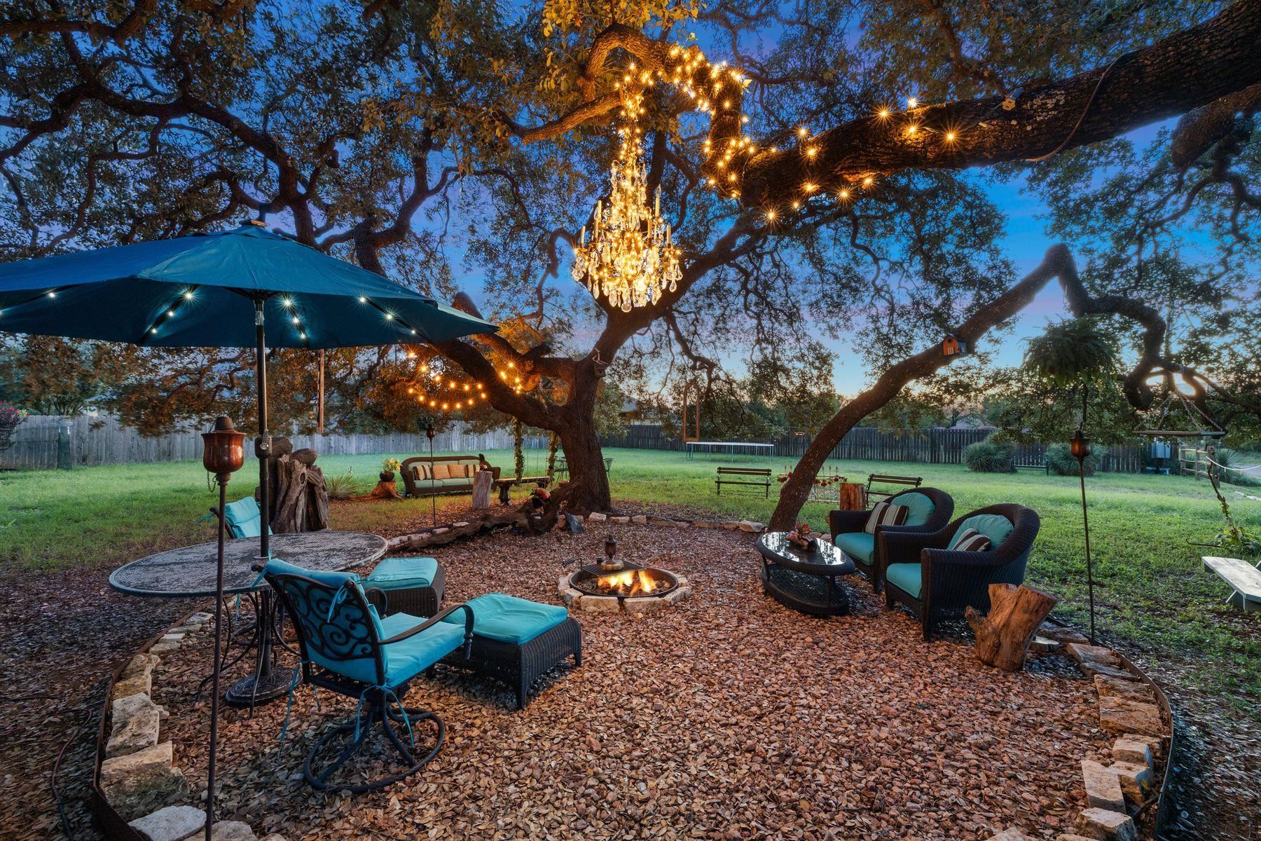 a view of a backyard with table and chairs under an umbrella