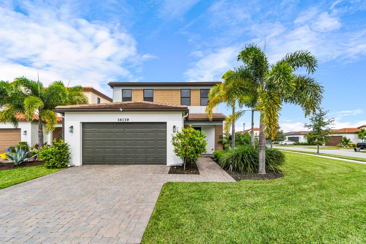 a front view of a house with a yard and garage