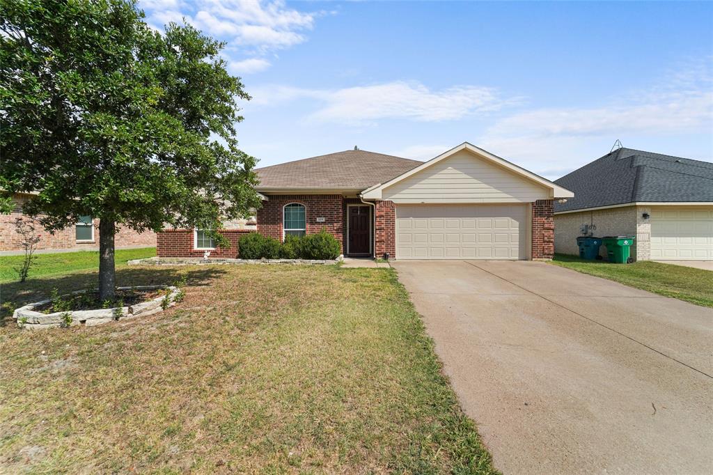 Ranch-style home featuring a garage and a front yard