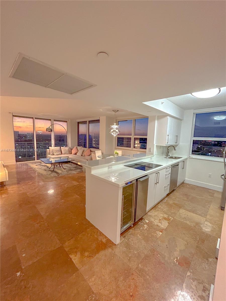 a large white kitchen with a large window and counter space