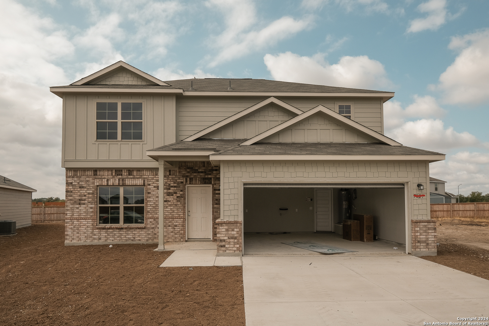 a front view of a house with a garage and balcony