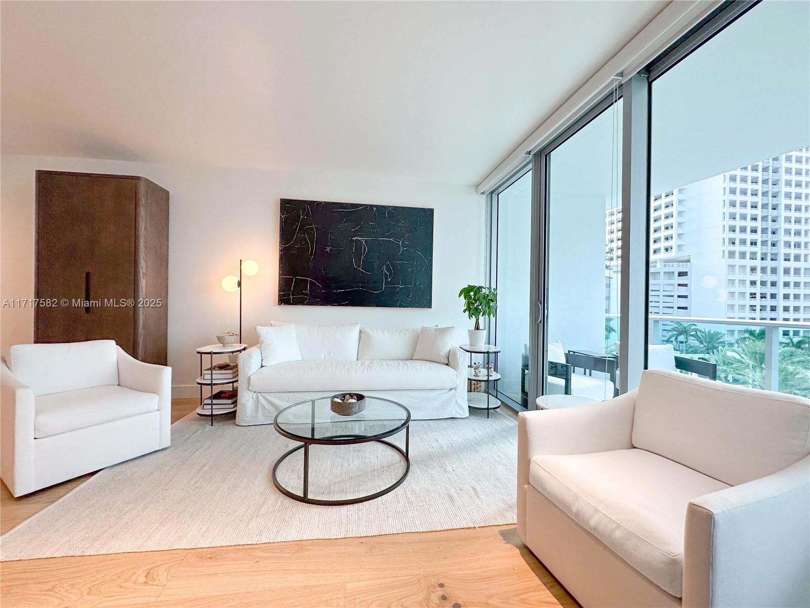 a living room with furniture a large window and a flat screen tv