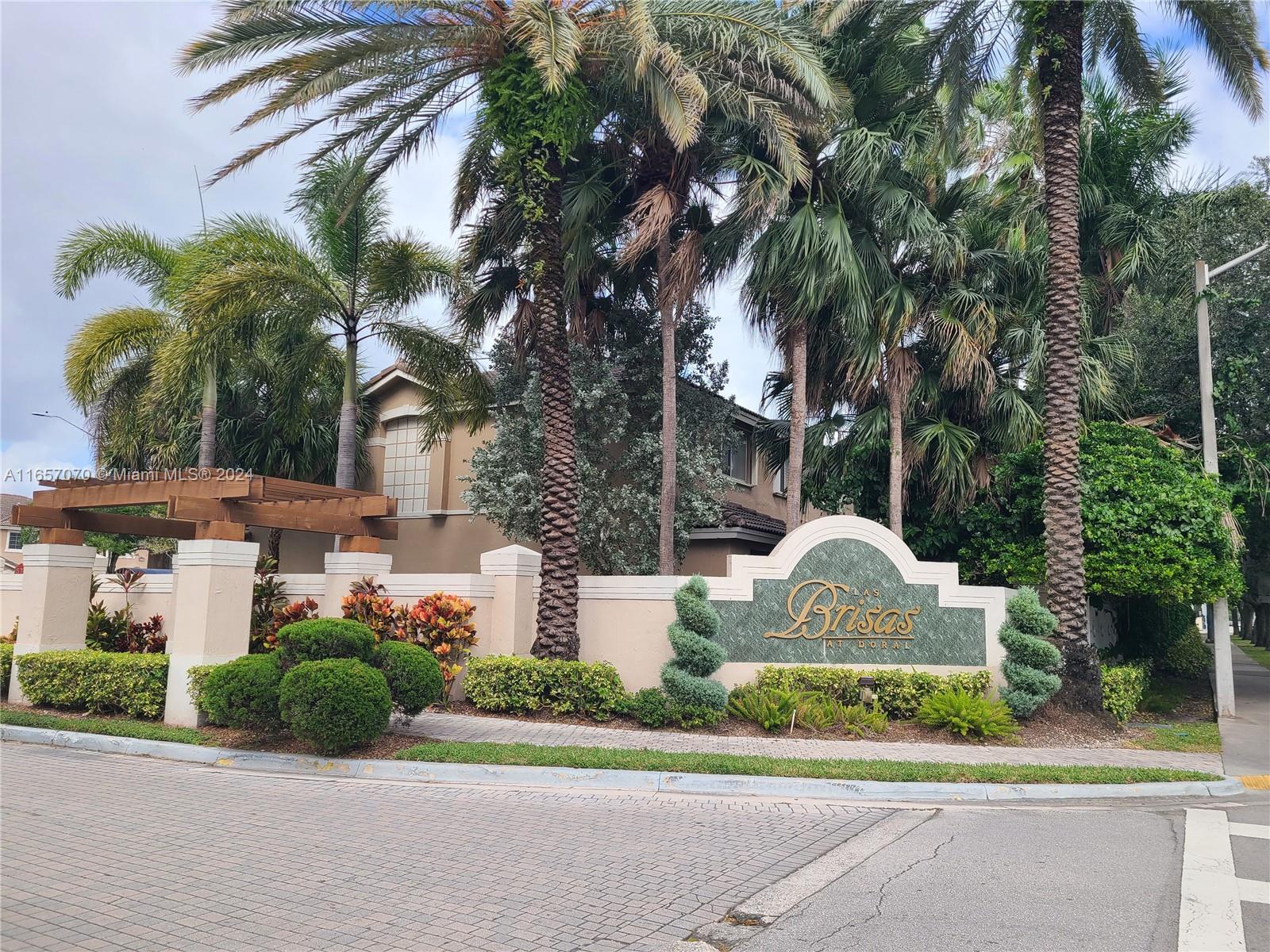 a front view of a house with fountain and garden