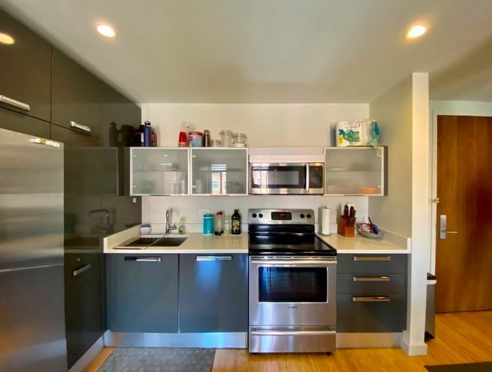 a kitchen with stainless steel appliances a stove a sink and a refrigerator