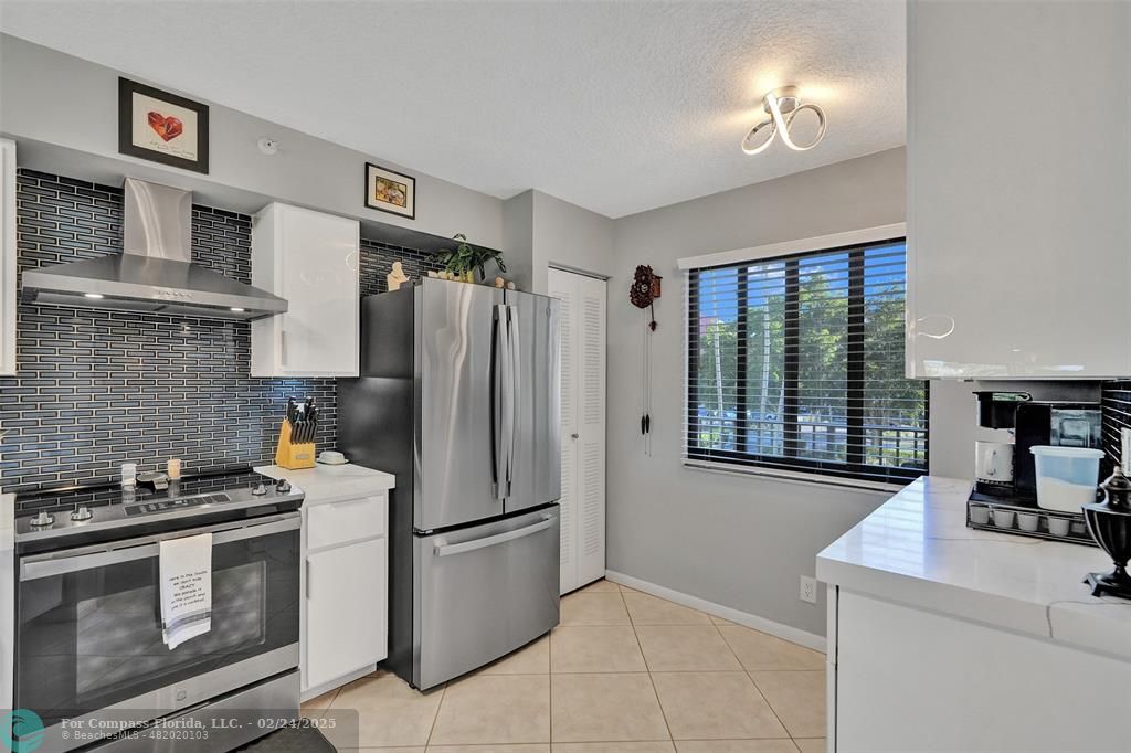 a kitchen with stainless steel appliances granite countertop a refrigerator and a stove