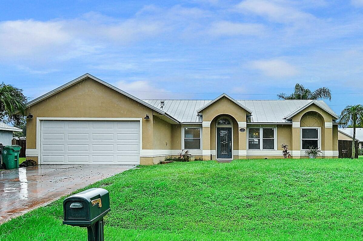 a front view of a house with yard and green space