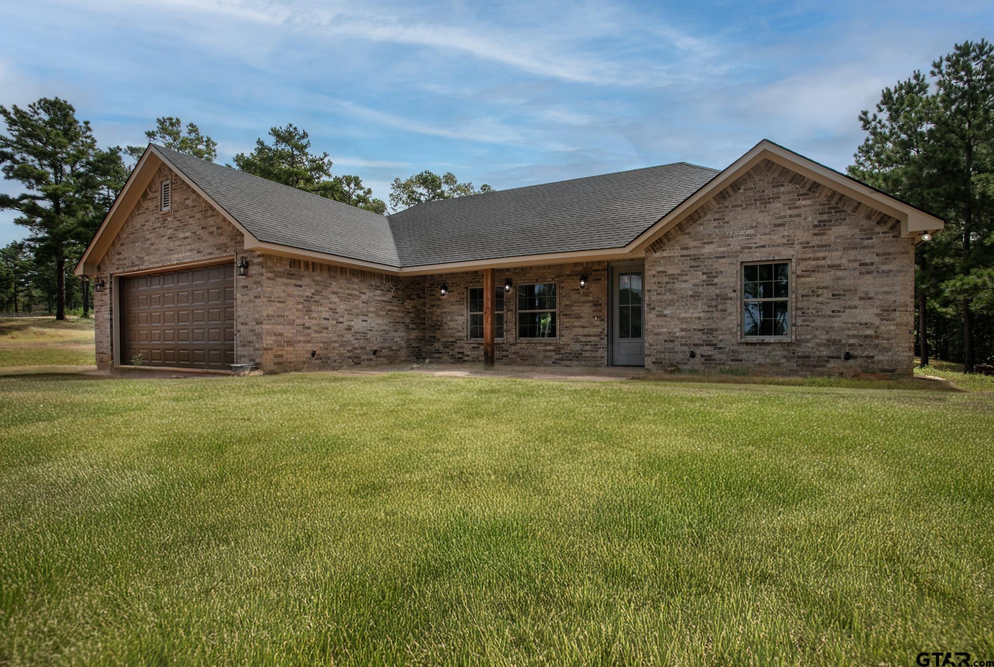 a front view of house with yard and garage