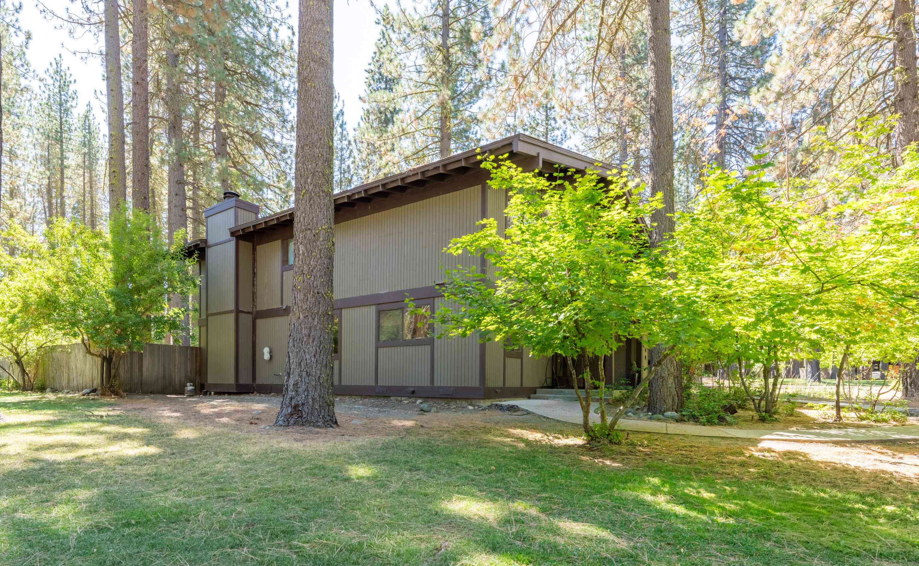 front view of a house with a yard and an trees