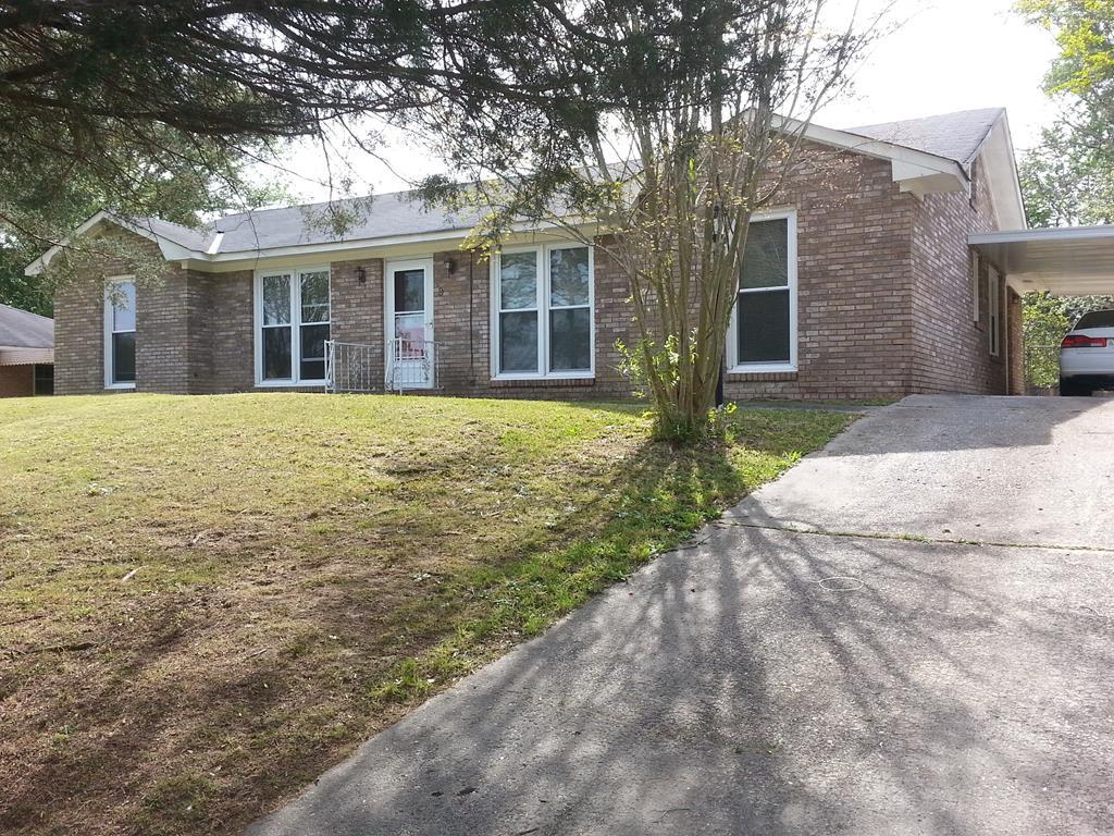 front view of a brick house with a yard