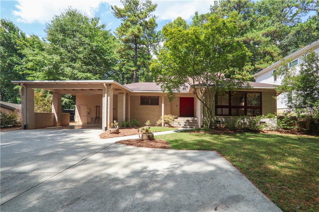 a front view of a house with a yard and trees