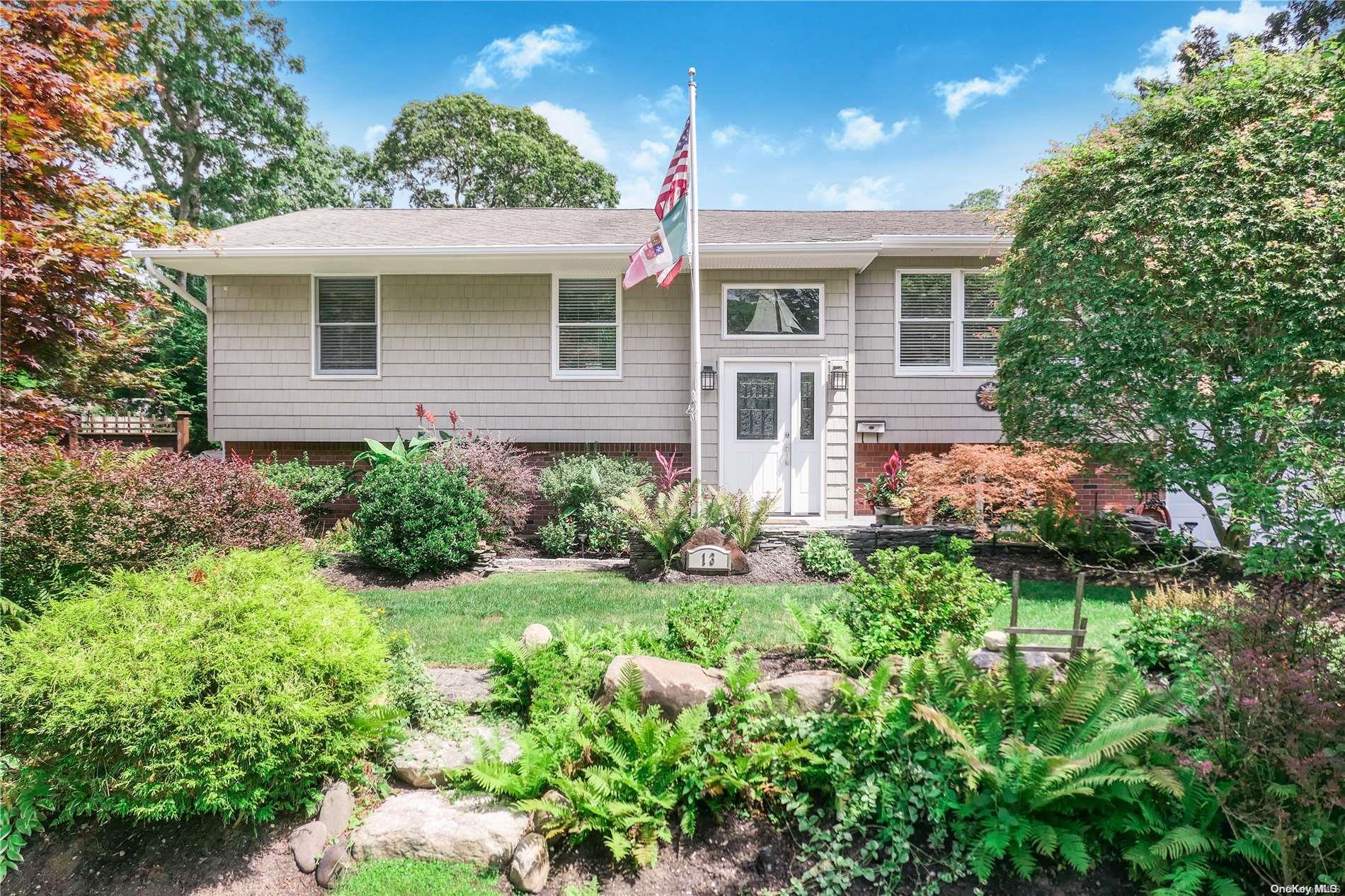 a front view of a house with a yard and potted plants