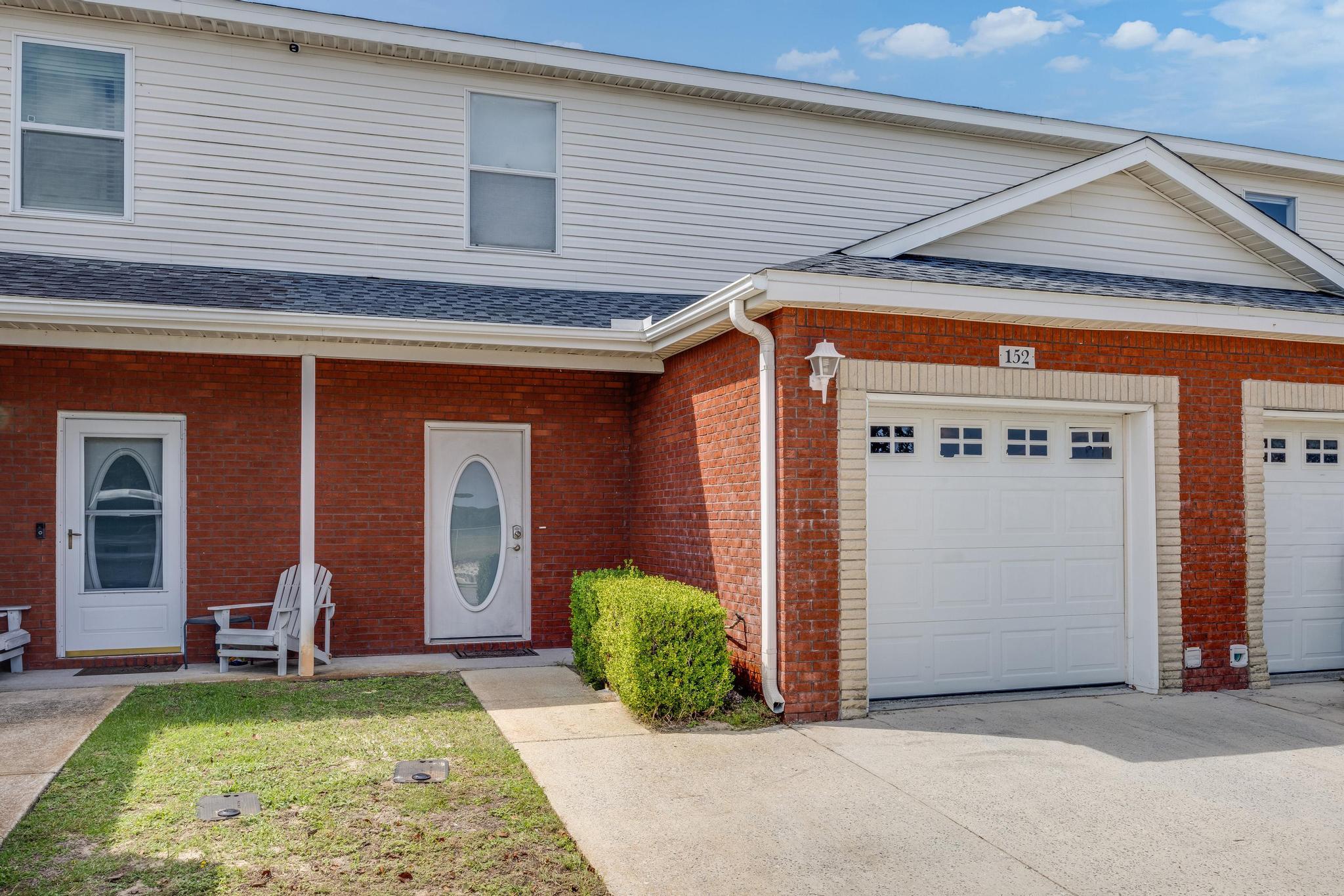 a front view of a house with a yard outdoor seating and garage