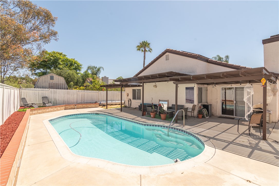 a view of a swimming pool with sitting area and furniture