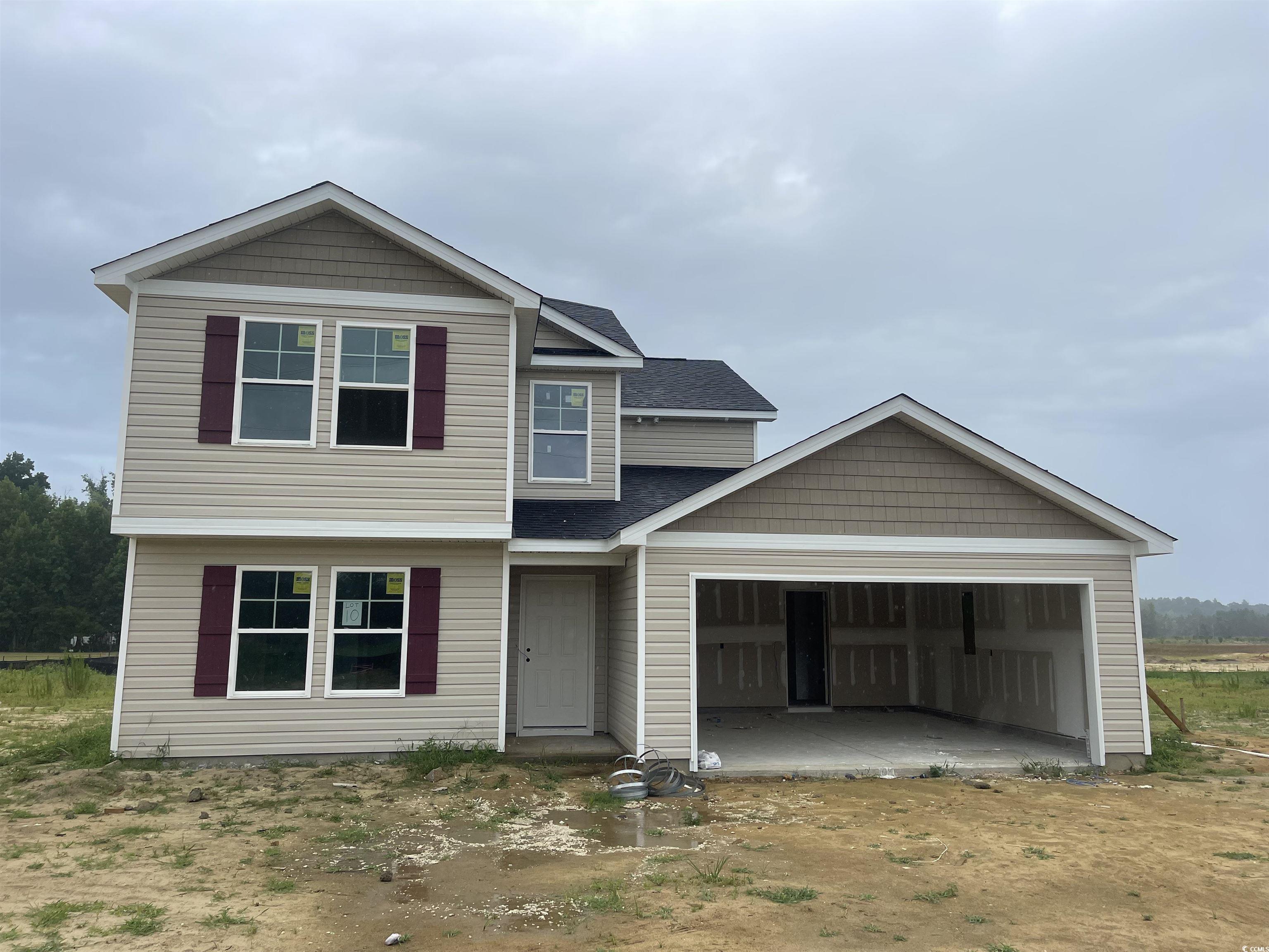 View of front of house with a garage and a patio a