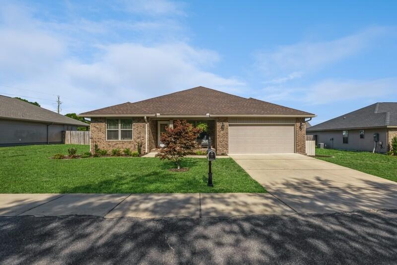 a front view of a house with a garden and yard