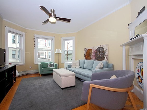 a living room with furniture fireplace and a large window