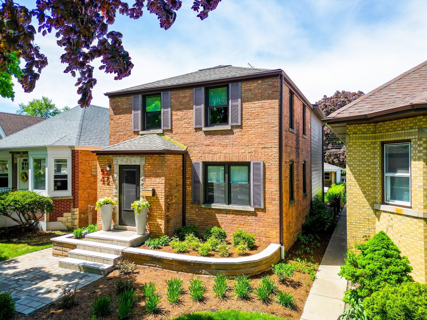 a front view of a house with a garden and plants